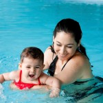 Mother teaching baby swimming